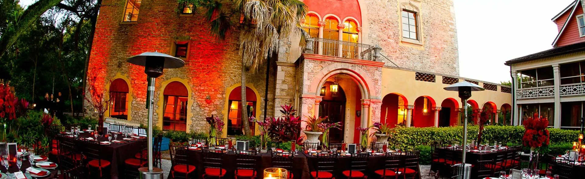 Exterior view of Deering Estate with palm trees, a golf course, and a clubhouse