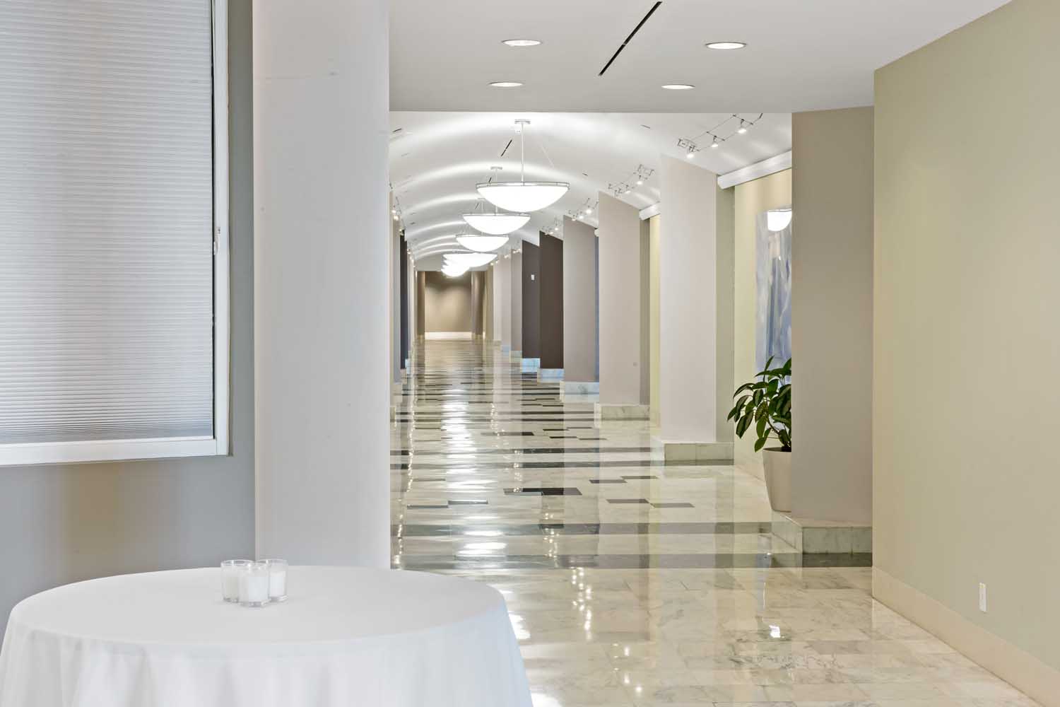 Marble foyer at Palmetto Bay Village Center with cocktail tables and a bright hallway leading to event spaces