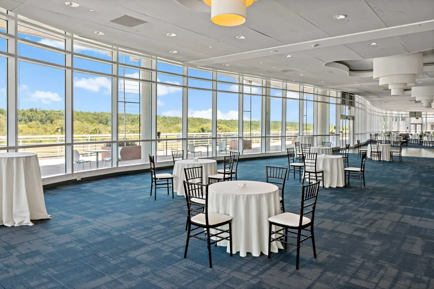Interior of the Palm Ballroom at Palmetto Bay Village Center with elegant table settings and natural light through large windows