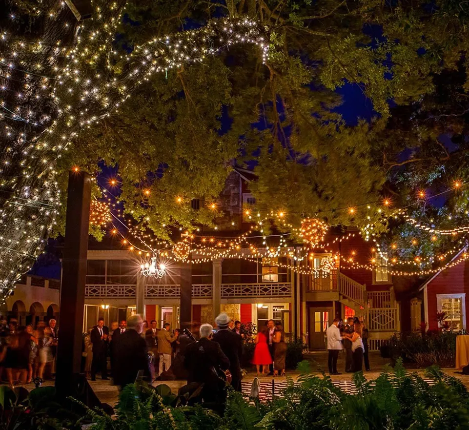 Exterior view of Deering Estate with palm trees, a golf course, and a clubhouse