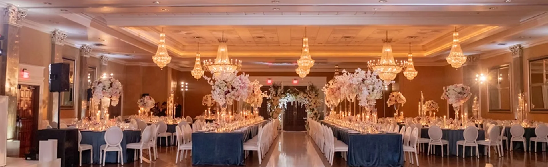 Exterior view of Coral Gables Country Club with palm trees, a golf course, and a clubhouse