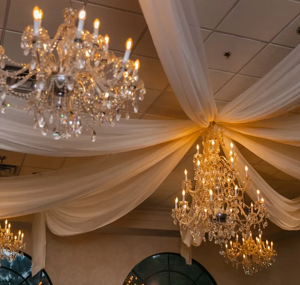 Exterior view of Coral Gables Country Club with palm trees, a golf course, and a clubhouse