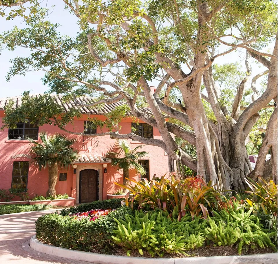 Exterior view of Thalatta Estate with palm trees, a golf course, and a clubhouse