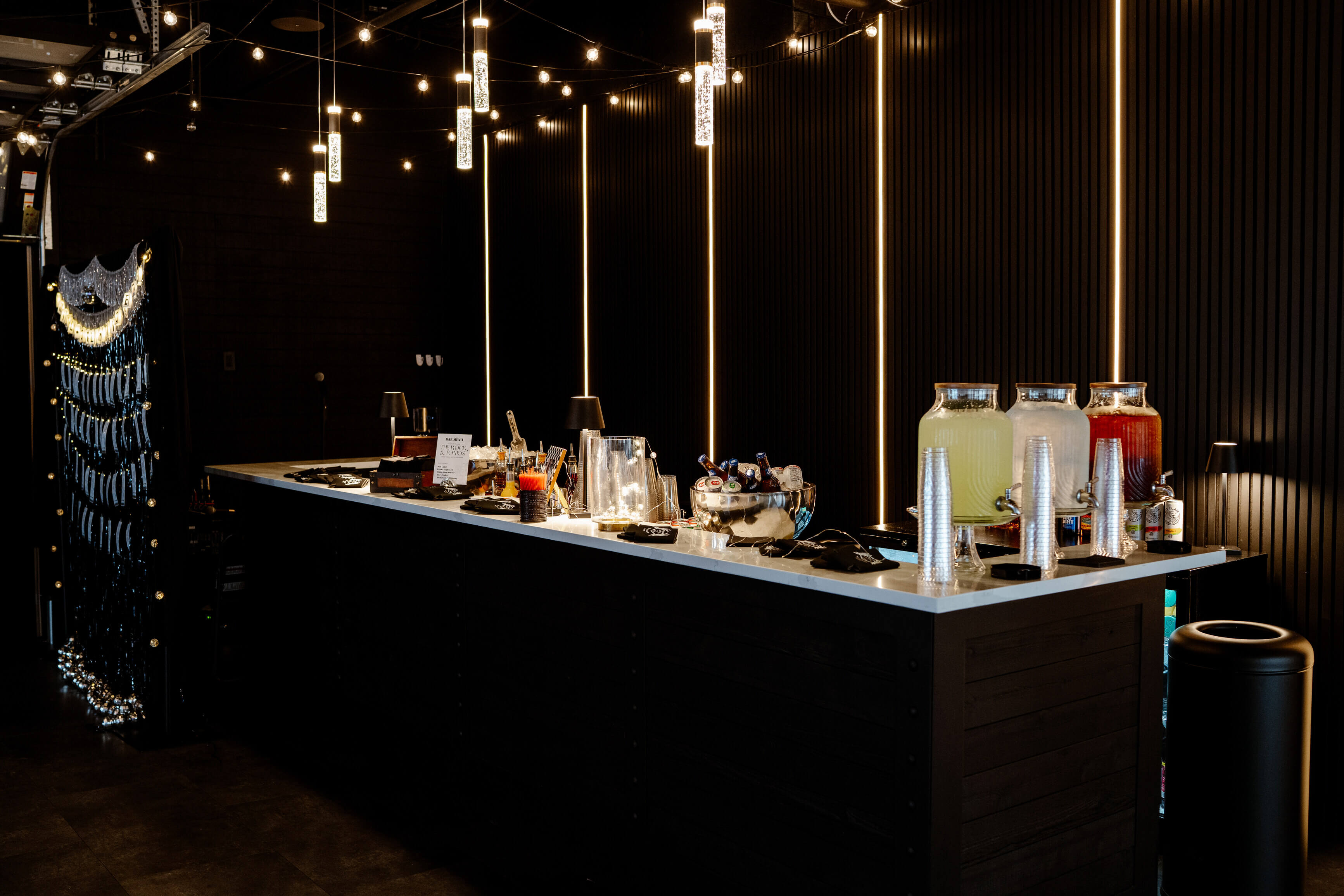 Rustic indoor wedding setup at Trellis 925 with draped ceiling, string lights, and elegant white table decor