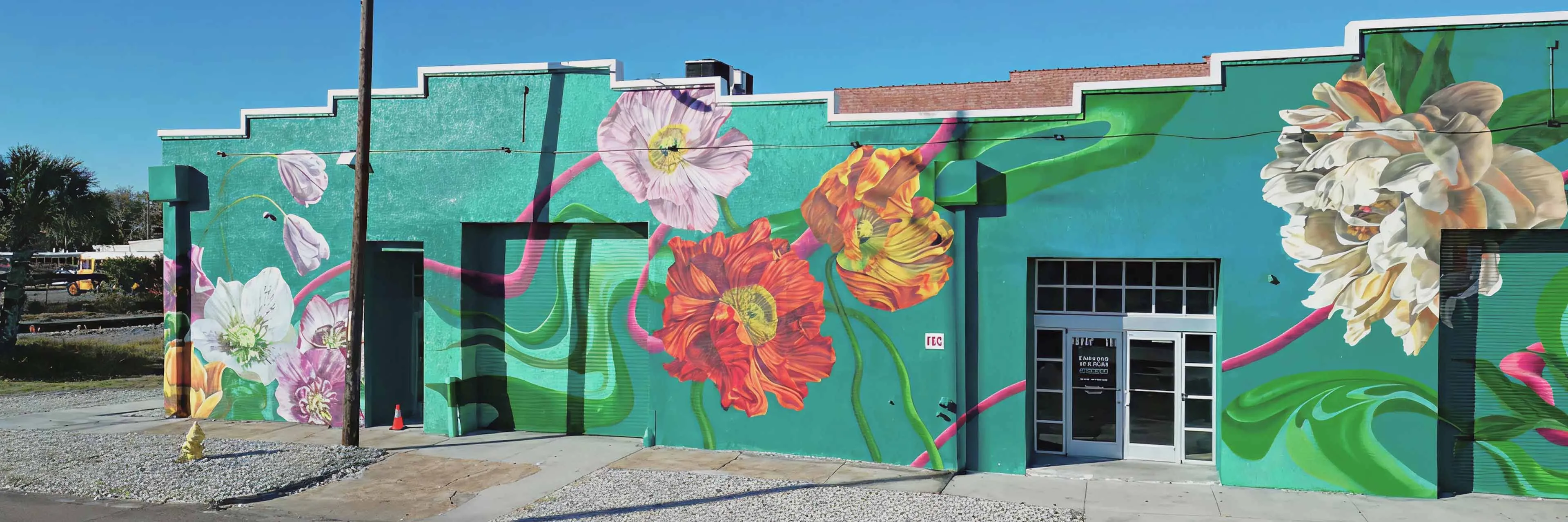 Outdoor view of The Emerald Stationvenue with vibrant floral mural painted on the building exterior