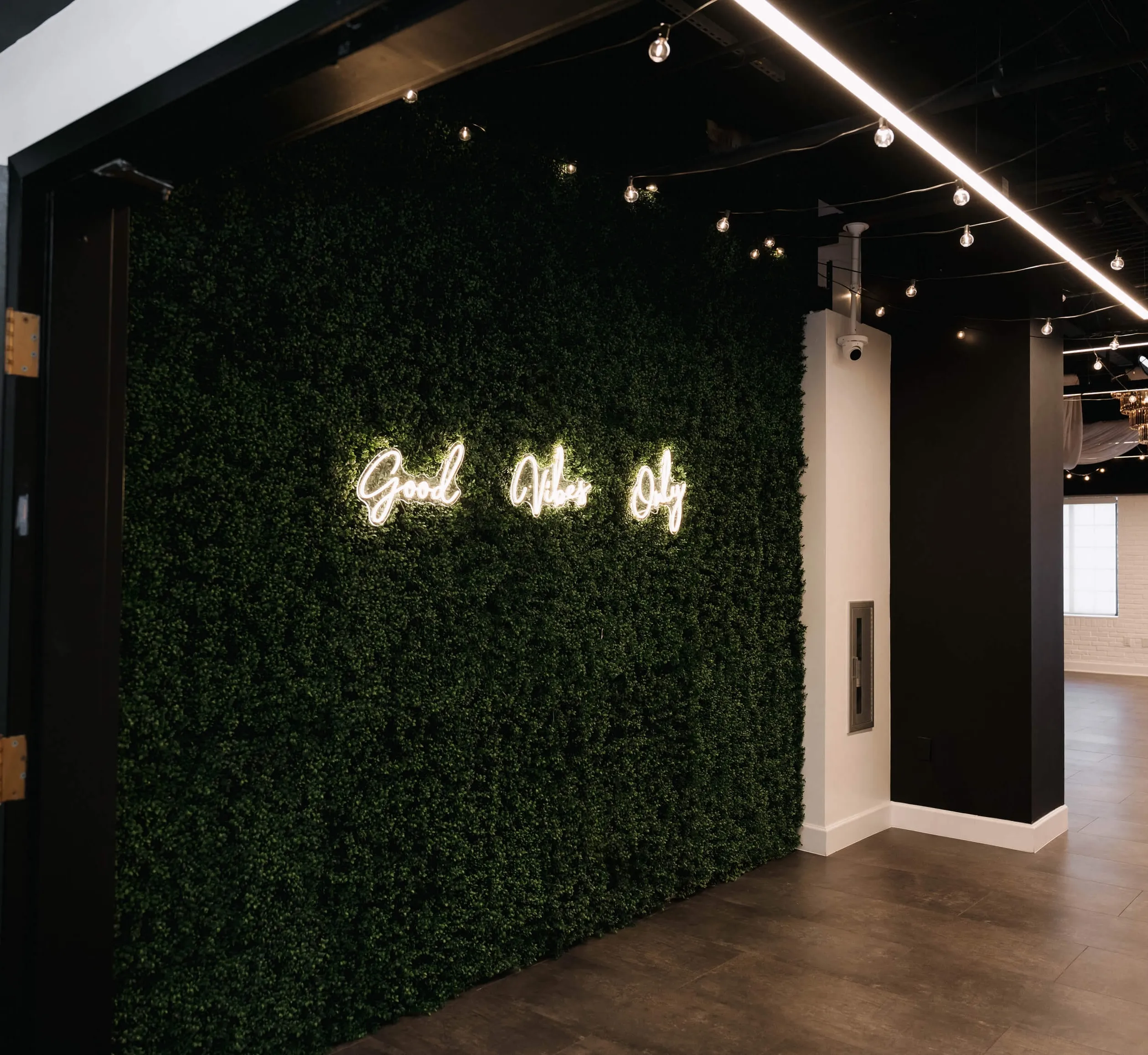 Indoor wedding ceremony at Trellis 925 with draped ceilings, string lights, white chairs, and brick walls for an intimate ambiance