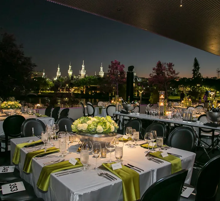 Outdoor wedding ceremony at Tampa Museum of Art with gold chairs and a floral arch by the waterfront at sunset