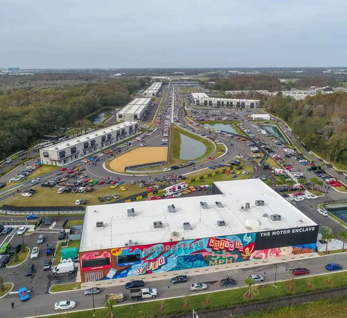 Aerial view of The Motor Enclave showing luxury and classic cars lined up along the track and event area